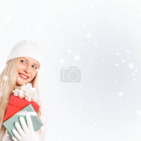 Téléchargez les photos : Bonne femme tenant cadeaux de Noël, fond argenté et neige - en image libre de droit