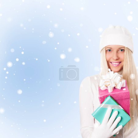Photo for Happy woman holding Christmas gifts on snow background - Royalty Free Image