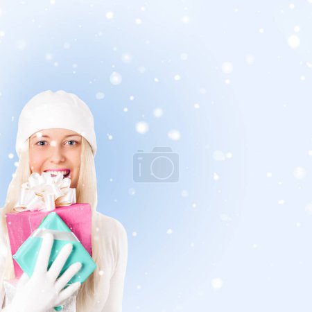 Foto de Mujer feliz sosteniendo regalos de Navidad, fondo azul y nieve - Imagen libre de derechos