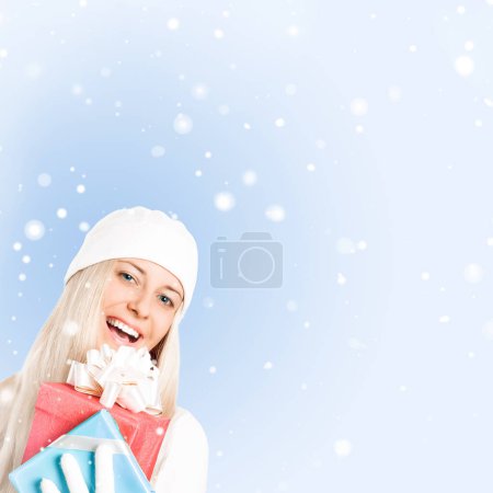 Photo for Happy woman holding Christmas gifts, blue background - Royalty Free Image