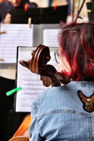 Téléchargez les photos : Jeune fille jouant du violoncelle dans un orchestre dans la rue - en image libre de droit