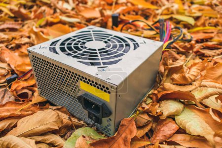 Photo for A discarded broken computer power supply lies in the autumn foliage - Royalty Free Image