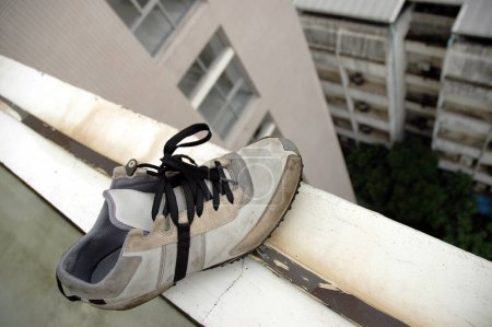 Téléchargez les photos : Chaussure restante au bord d'un toit de bâtiment - en image libre de droit