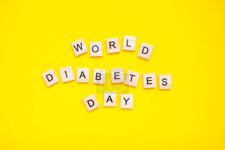 Téléchargez les photos : L'inscription de blocs de bois Journée mondiale du diabète sur un fond jaune - en image libre de droit