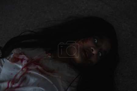 Foto de Horror evil woman ghost creepy lying dead in a dark room at house - Imagen libre de derechos