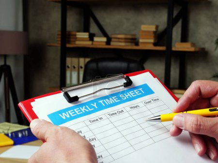 Photo for The manager fills in the weekly time sheet. - Royalty Free Image