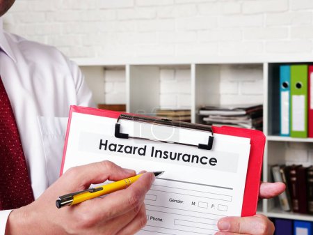 Photo for Insurer shows Hazard insurance form for signing. - Royalty Free Image