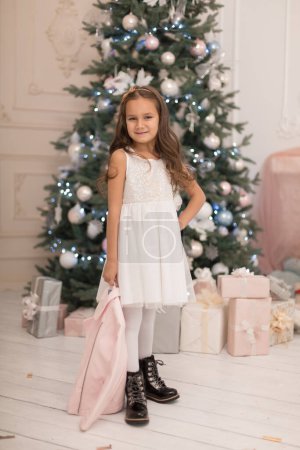 Téléchargez les photos : Belle petite fille posant près du sapin de Noël - en image libre de droit