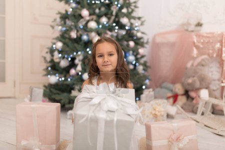 Foto de Feliz infancia, cuento mágico de Navidad. Princesita con el regalo de Papá Noel para Navidad - Imagen libre de derechos