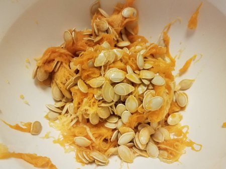 Photo for Pumpkin seeds and orange pulp in container - Royalty Free Image