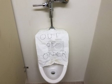 Photo for Paper out of order sign on bathroom urinal - Royalty Free Image