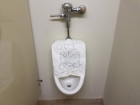 Photo for Paper out of order sign on bathroom urinal - Royalty Free Image