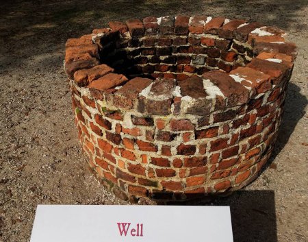 Téléchargez les photos : Red brick well with sign or label - en image libre de droit