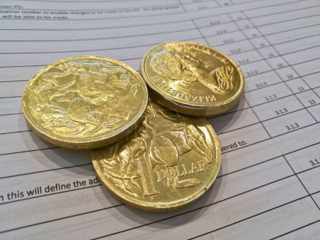 Téléchargez les photos : Trois pièces d'or en dollars australiens sur feuille de facture - en image libre de droit