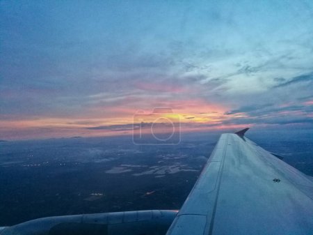 Téléchargez les photos : Scène de coucher de soleil depuis le siège de fenêtre de l'avion volant au-dessus des nuages - en image libre de droit