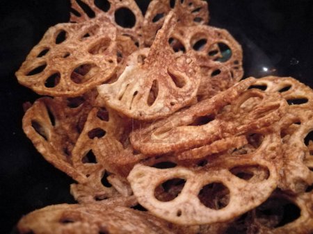 Photo for Golden fried crispy lotus root chips in black bowl - Royalty Free Image