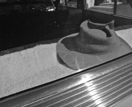 Foto de Sombrero de hombre izquierdo dentro del parabrisas del coche en blanco y negro - Imagen libre de derechos