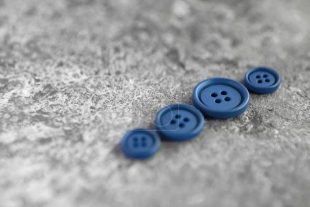 Foto de Montón de botones azules mate sobre fondo de hormigón - Imagen libre de derechos