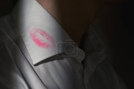 Téléchargez les photos : Marques de rouge à lèvres sur le col d'une chemise blanche pour hommes - en image libre de droit