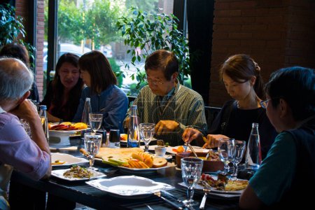 Téléchargez les photos : Touristes asiatiques manger, assis et parler à Restauration de Tbilissi. Plats traditionnels et nourriture nationale. - en image libre de droit