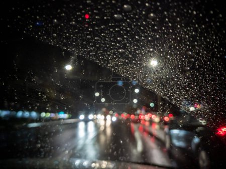 Foto de Foto desenfocada de la vista del conductor nocturno en la ciudad desde el coche de dirección derecho - Imagen libre de derechos