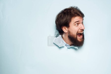 Téléchargez les photos : Un homme mécontent regarde par derrière le mur du travail du directeur de bureau - en image libre de droit