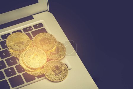 Foto de "Bitcoin en el ordenador portátil, moneda de oro con moneda de cambio digital
" - Imagen libre de derechos