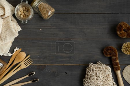 Photo for Zero waste kit. Set of eco friendly bamboo cutlery and cleaning brushes, mesh cotton bags, glass jars, loofah and bamboo toothbrushes. Natural and reusable items accessories on wood surface - Royalty Free Image