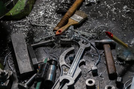Photo pour "set of tools covered with aluminium metal swarf on machinery worker table" - image libre de droit