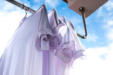 Téléchargez les photos : T-shirts blancs sur corde à linge contre ciel bleu
. - en image libre de droit