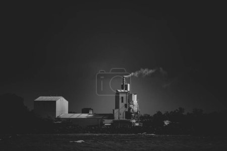 Foto de "humo de fábrica liberado al aire fotografía de larga distancia en blanco y negro
" - Imagen libre de derechos