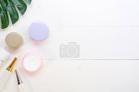 Photo for Top view of cosmetics and skin care products on white wood table - Royalty Free Image