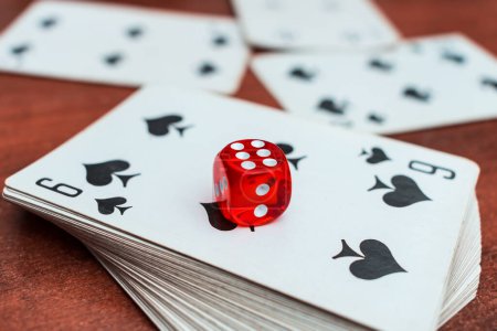 Photo for "Red dice lie on a deck of playing cards in a casino. Casino gambling with dice and cards" - Royalty Free Image