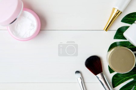 Foto de Vista superior de cosméticos y productos para el cuidado de la piel en mesa de madera blanca - Imagen libre de derechos