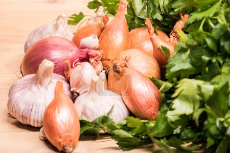 Photo for Garlic onion shallot parsley on a wooden board - Royalty Free Image