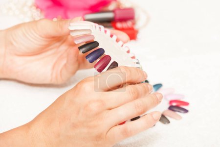 Téléchargez les photos : "Mains d'une femme qui choisit la couleur de son vernis à ongles
" - en image libre de droit