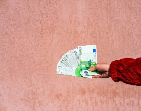 Foto de "Mano sosteniendo y mostrando un fan del dinero en euros o dando dinero. Wo.
" - Imagen libre de derechos