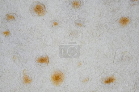 Photo for "Texture of thin traditional freshly baked homemade oriental bread. Close-up Armenian pita bread - lavash as a textured bread background." - Royalty Free Image