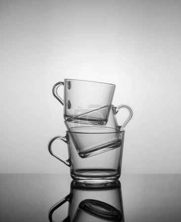 Photo for Empty tea mugs stacked on top of each other on dark background - Royalty Free Image