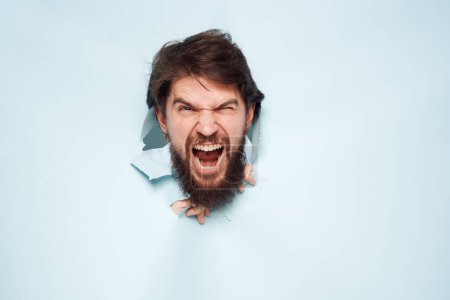 Photo for Screaming bearded man peeking out from behind the wall emotions work - Royalty Free Image