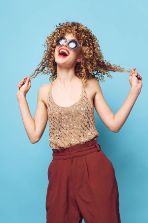 Téléchargez les photos : Femme cheveux bouclés tenue par les mains joie style de vie lunettes de soleil décoration de mode - en image libre de droit