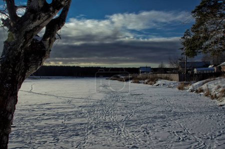 Foto de Casa junto a un estanque en invierno en la nieve. La vida en la naturaleza junto al agua. - Imagen libre de derechos