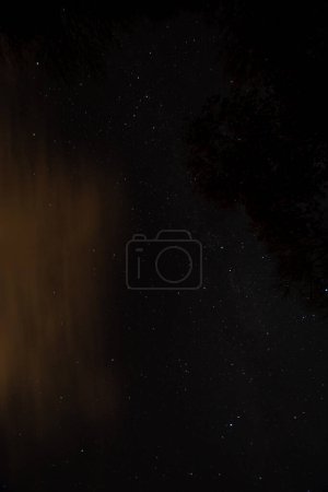 Téléchargez les photos : Un ciel nocturne plein d'étoiles et de nuages orange - en image libre de droit