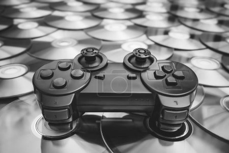 Téléchargez les photos : Un vieux joystick usé d'une console de jeu se trouve sur des disques avec des jeux vidéo - en image libre de droit