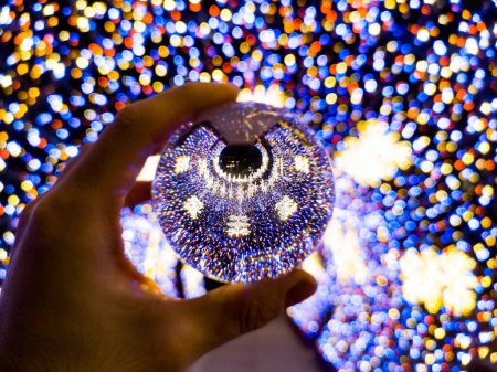 Téléchargez les photos : "Tunnel de Noël coloré rond composé de lumières de Noël réfléchies dans une boule de verre en cristal" - en image libre de droit