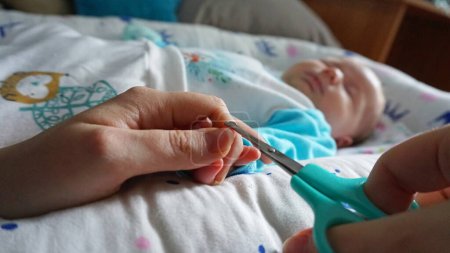 Foto de Las uñas de un niño recién nacido se cortan con tijeras - Imagen libre de derechos