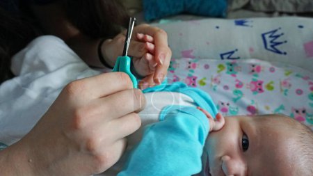 Foto de Las uñas de un niño recién nacido se cortan con tijeras - Imagen libre de derechos