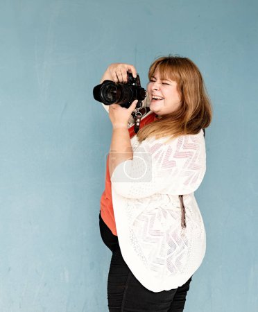 Téléchargez les photos : Plus femme photographe taille au mur bleu - en image libre de droit