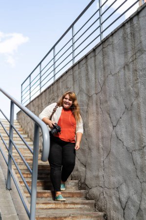 Téléchargez les photos : Plus femme photographe taille à l'extérieur sur les escaliers de construction - en image libre de droit