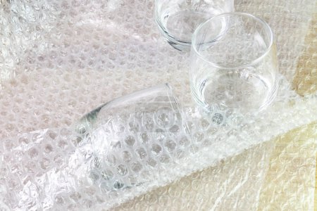 Foto de El vidrio de agua de la cubierta de la envoltura de burbuja en la caja para el producto de protección - Imagen libre de derechos